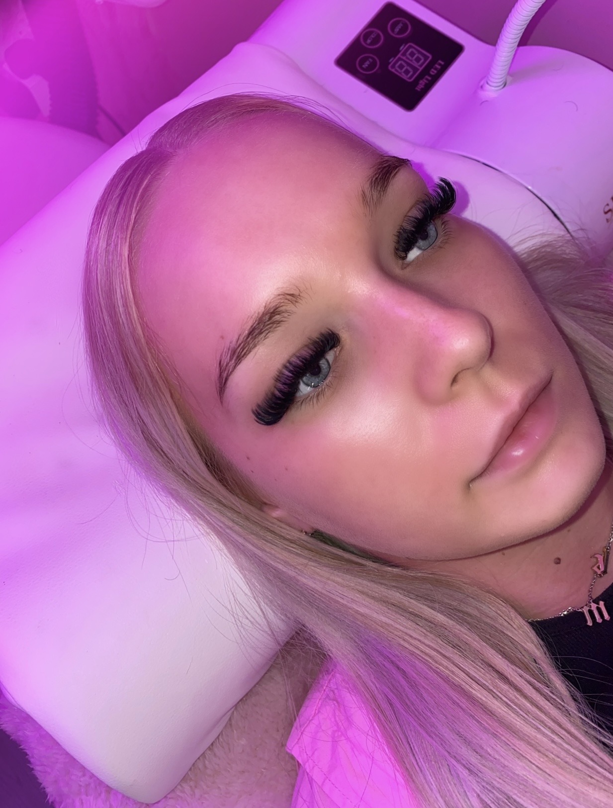 Full set of lash extensions under the salon's pink light